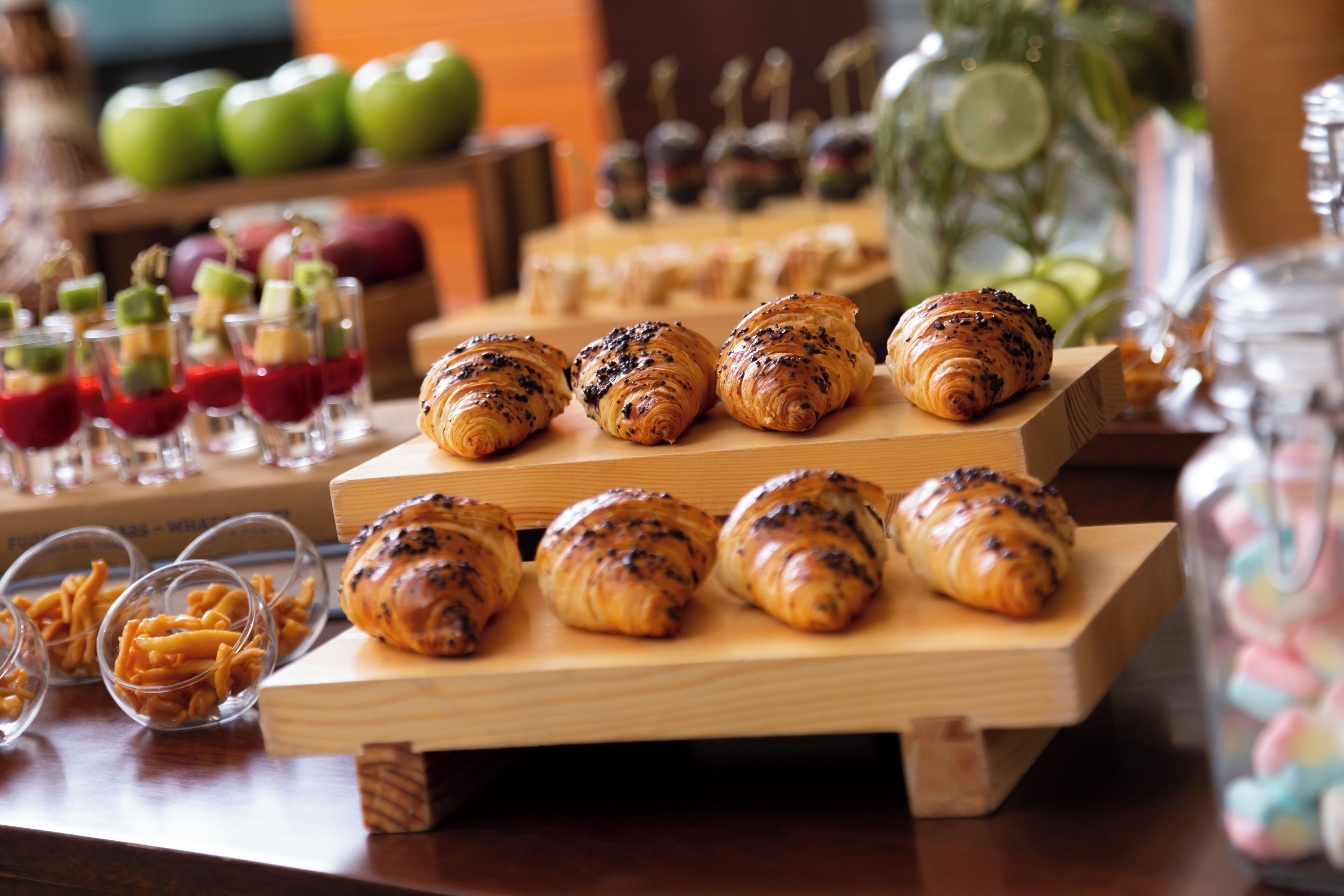 A buffet table with various food items including pastries and desserts.