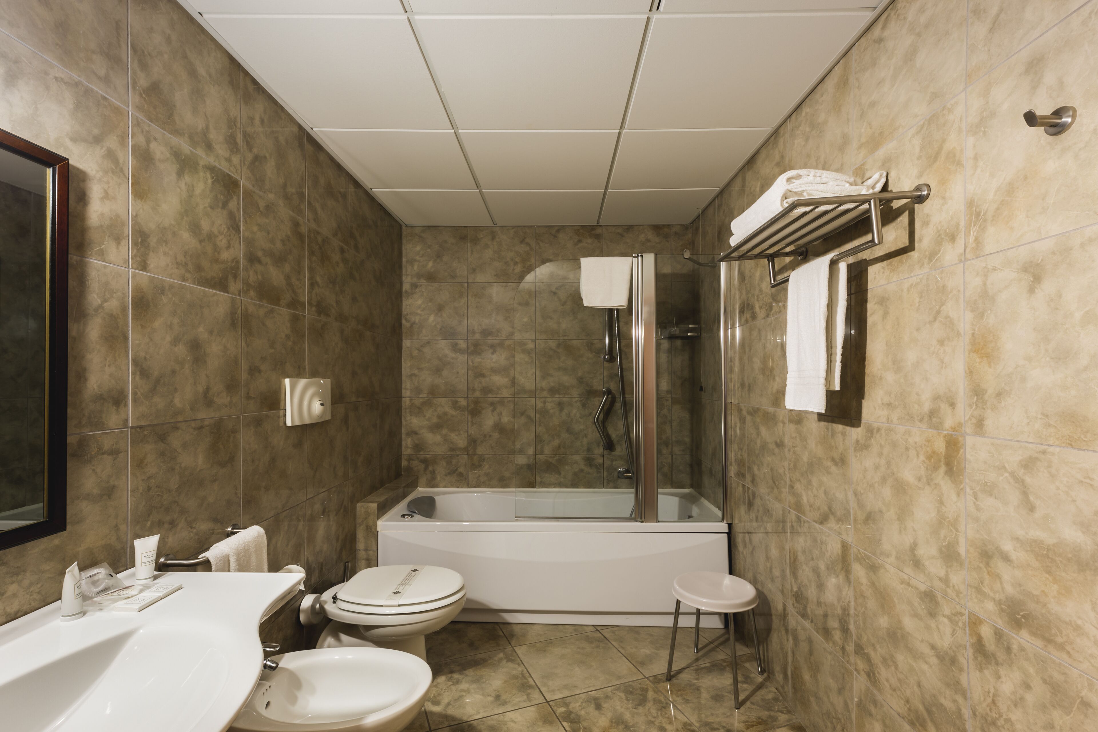 A modern bathroom with a bathtub, toilet, and sink.