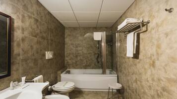 A modern bathroom with a bathtub, toilet, and sink.