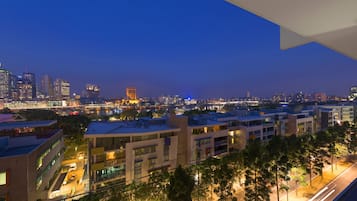 Un paisaje urbano al anochecer con edificios modernos, un río y un puente.