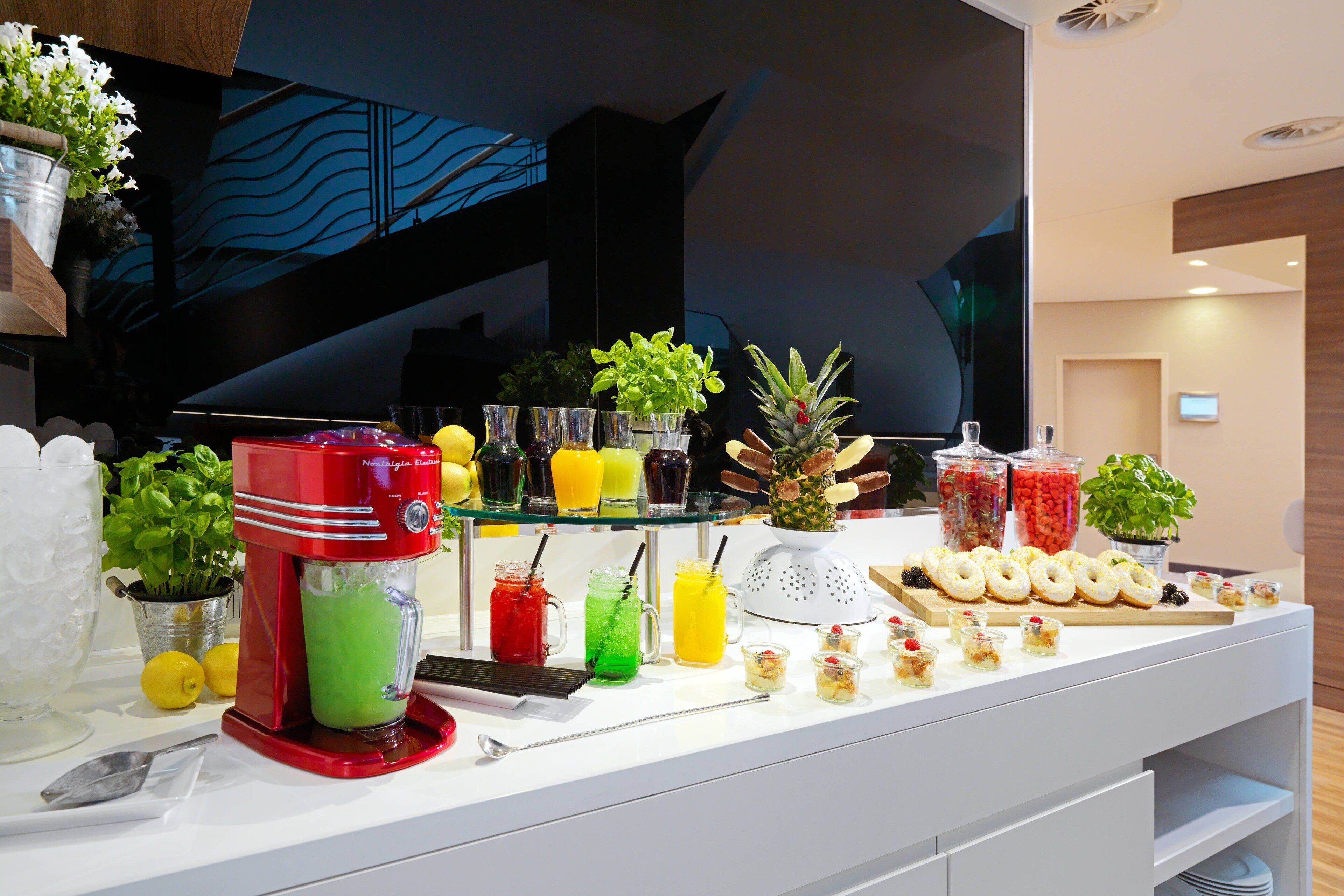 A buffet with a variety of drinks, fresh fruits, and pastries.