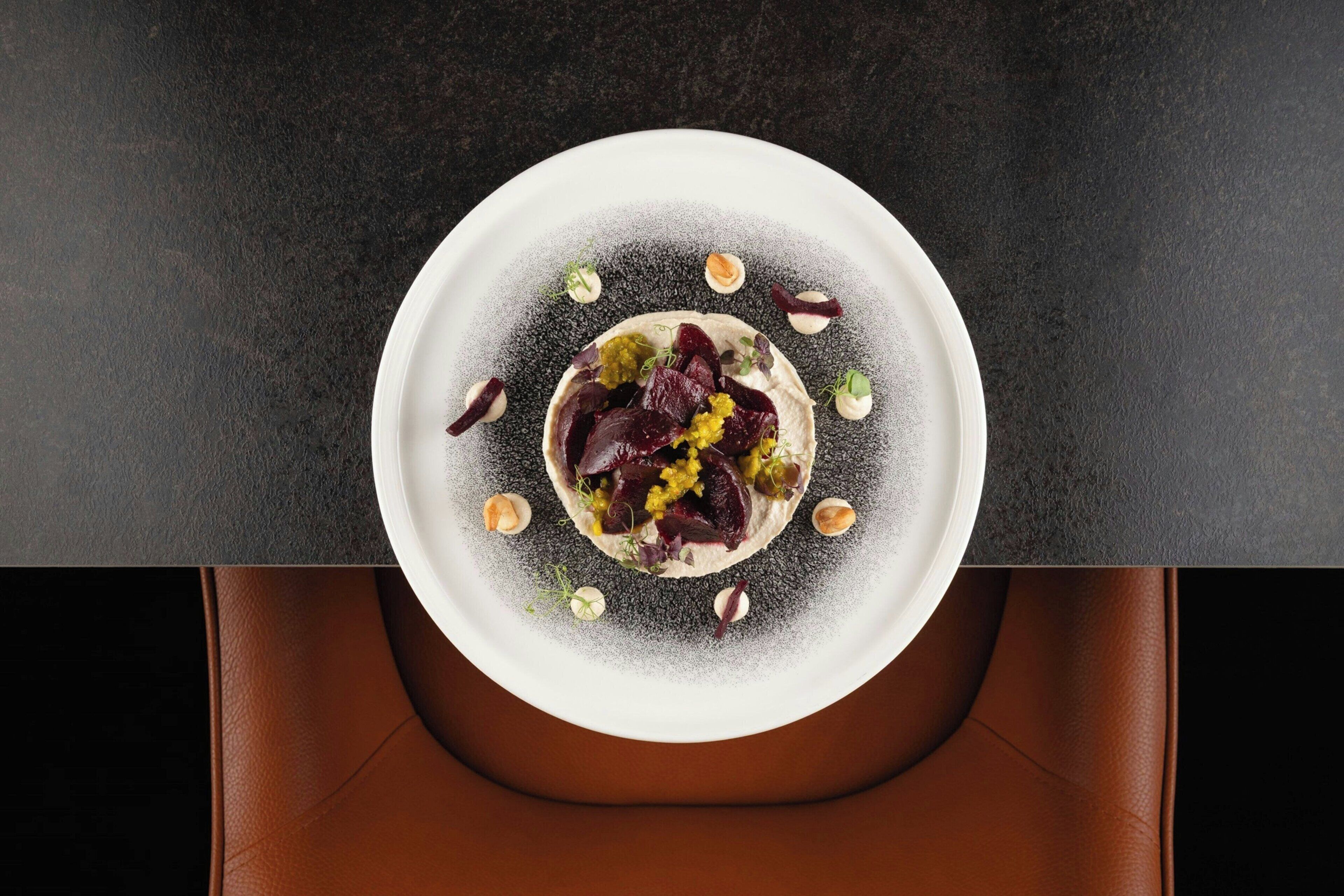 A white plate with a dish on a dark table.
