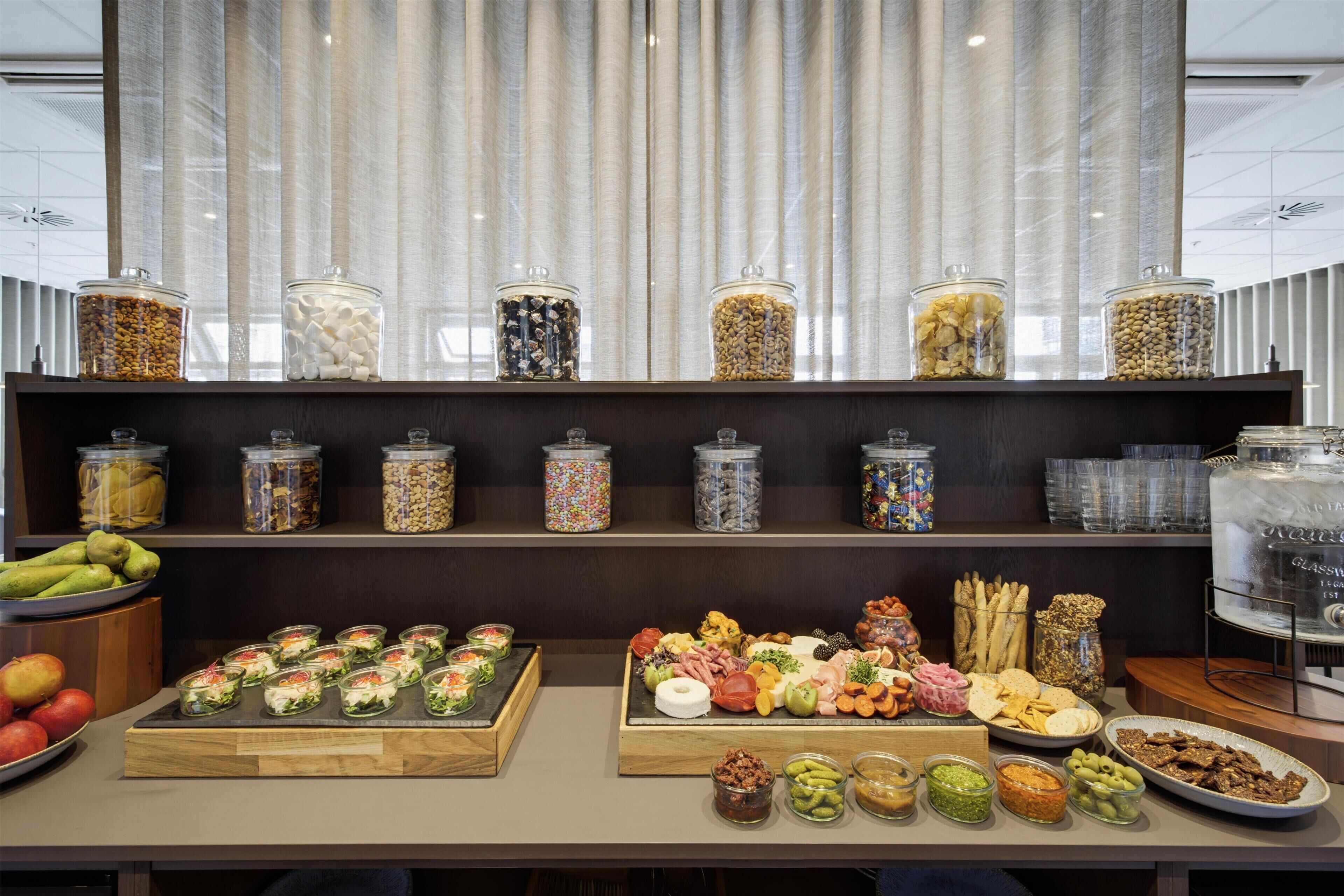 A buffet setup with various food items and condiments.