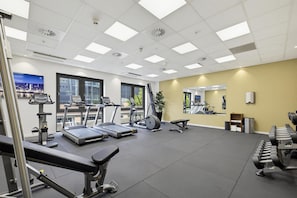 Ein Fitnessstudio mit Laufbändern, Ergometer und Kurzhanteln.