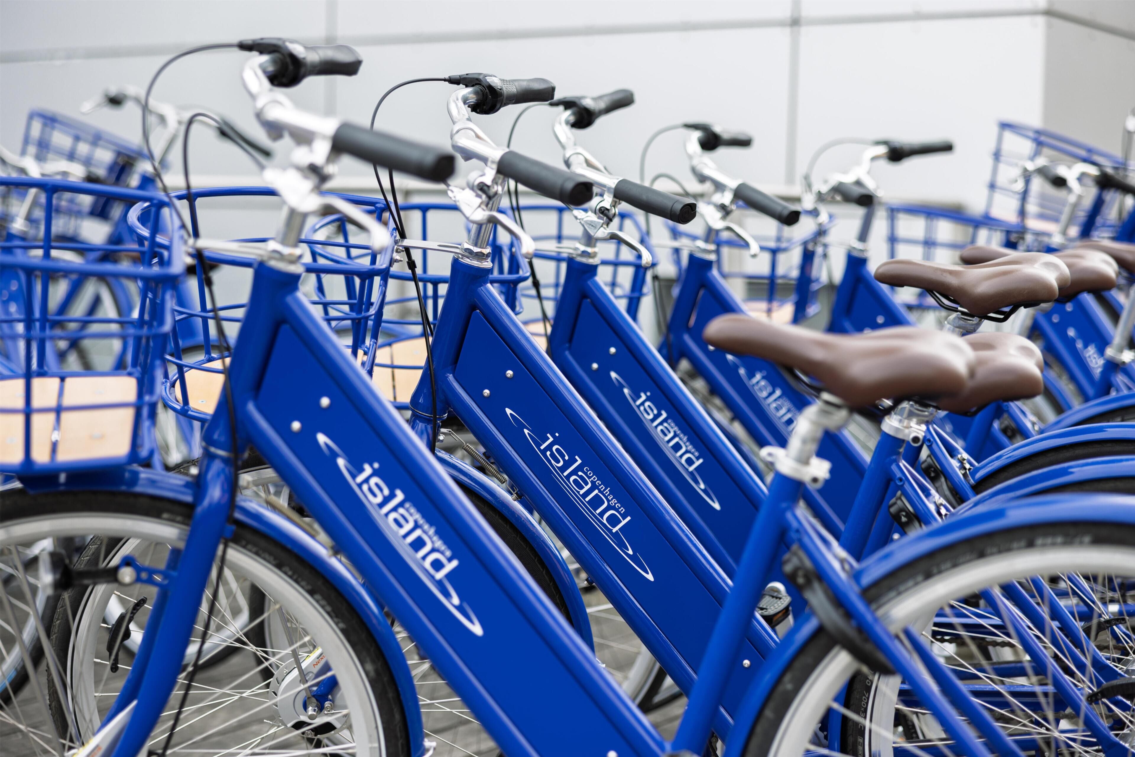 A row of blue bicycles with 'Copenhagen' branding, indicating a bike-sharing service.
