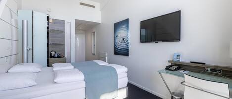 Habitación de hotel moderna con cama, escritorio, televisor y baño.