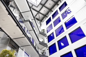 Een meerlaags gebouw met een modern architectonisch ontwerp, met glazen balustrades en een reeks ramen.