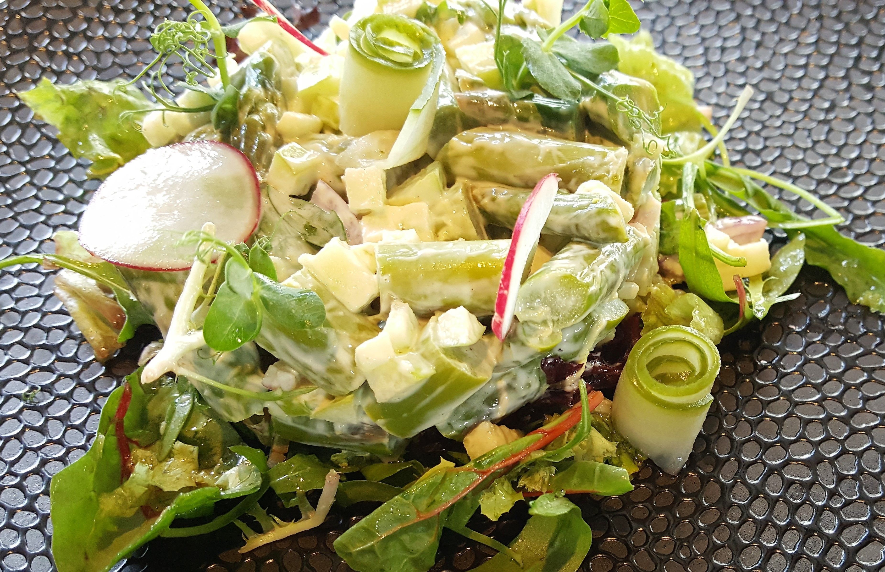 En sallad med olika sorters grönsaker och bladgrönt.