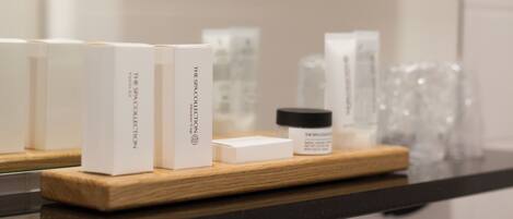 A wooden tray with spa collection boxes and a jar on a black countertop.