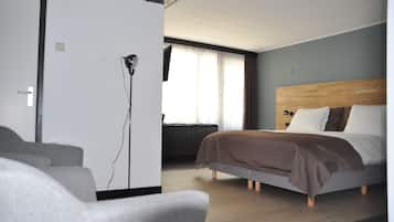 A modern hotel room with a bed, a desk, and a chair.