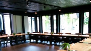 A conference room with long tables and chairs, large windows, and a wooden ceiling. - Hotel Bieze (Borger)