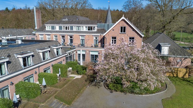 A large brick building with multiple windows and a prominent tower. - Fletcher Boshotel de Lochemse Heuvels (Barchem)