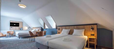 Una habitación de hotel moderna con una cama grande, un escritorio y una zona de estar.