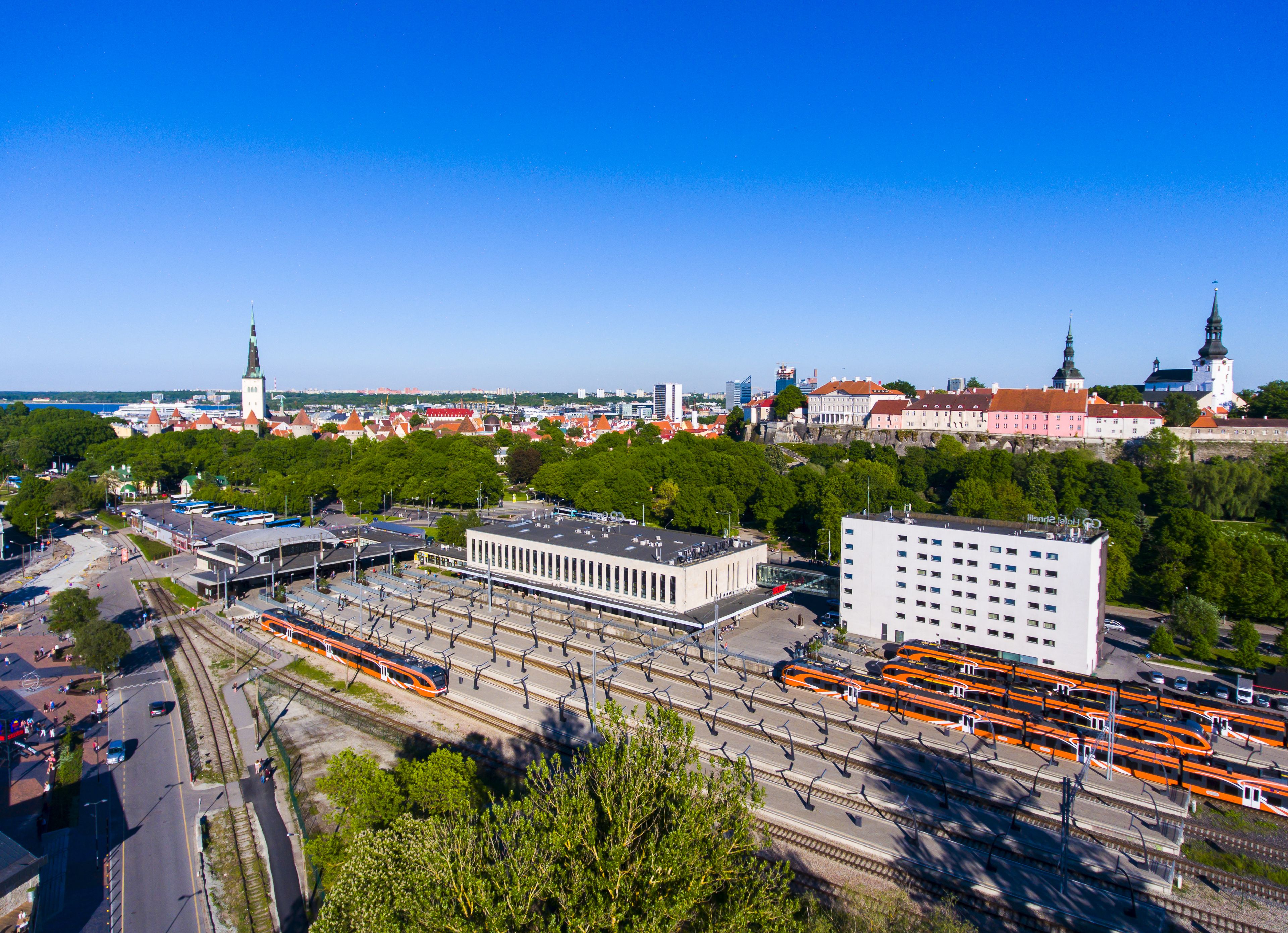 A cityscape with a prominent train station and a large building with a modern design.
