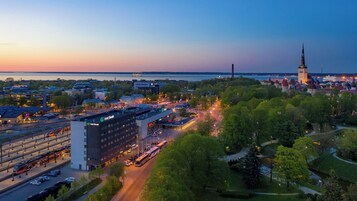 Stadsgezicht met een opvallend hotel, een kerk en een rivier.