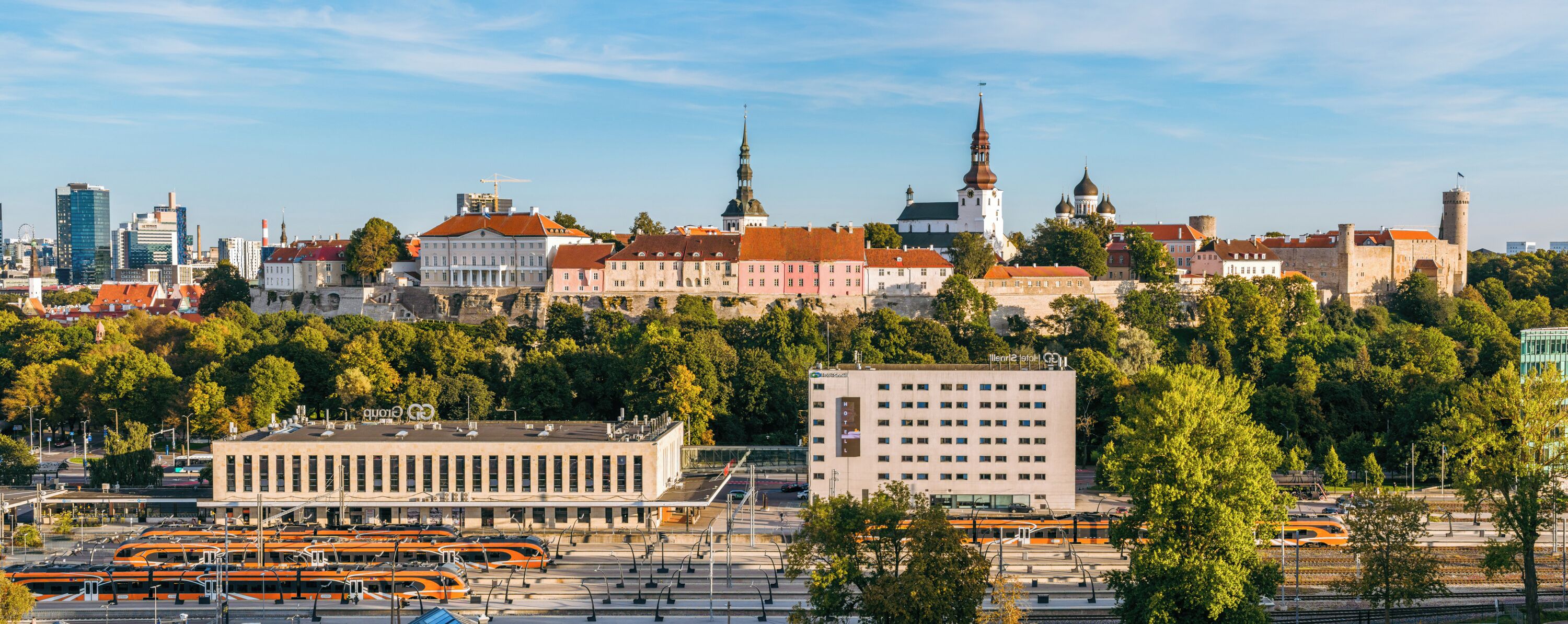 Une vue urbaine comprenant des bâtiments historiques, un bâtiment moderne et une station de tramway.