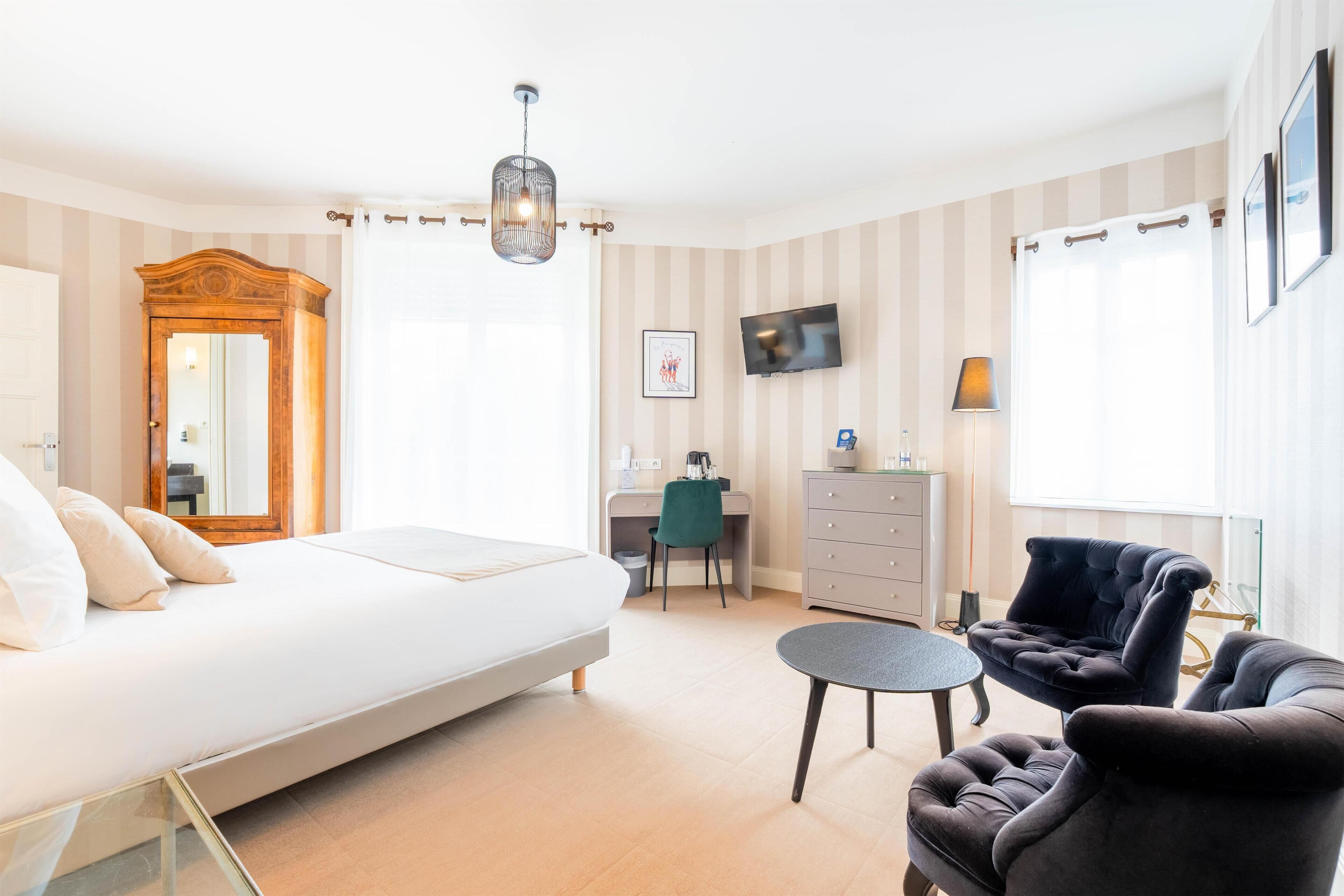 Una habitación de hotel moderna con una cama, un escritorio, una silla y un televisor.