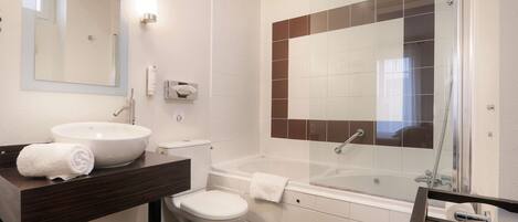 A modern bathroom with a large sink, toilet, and bathtub.