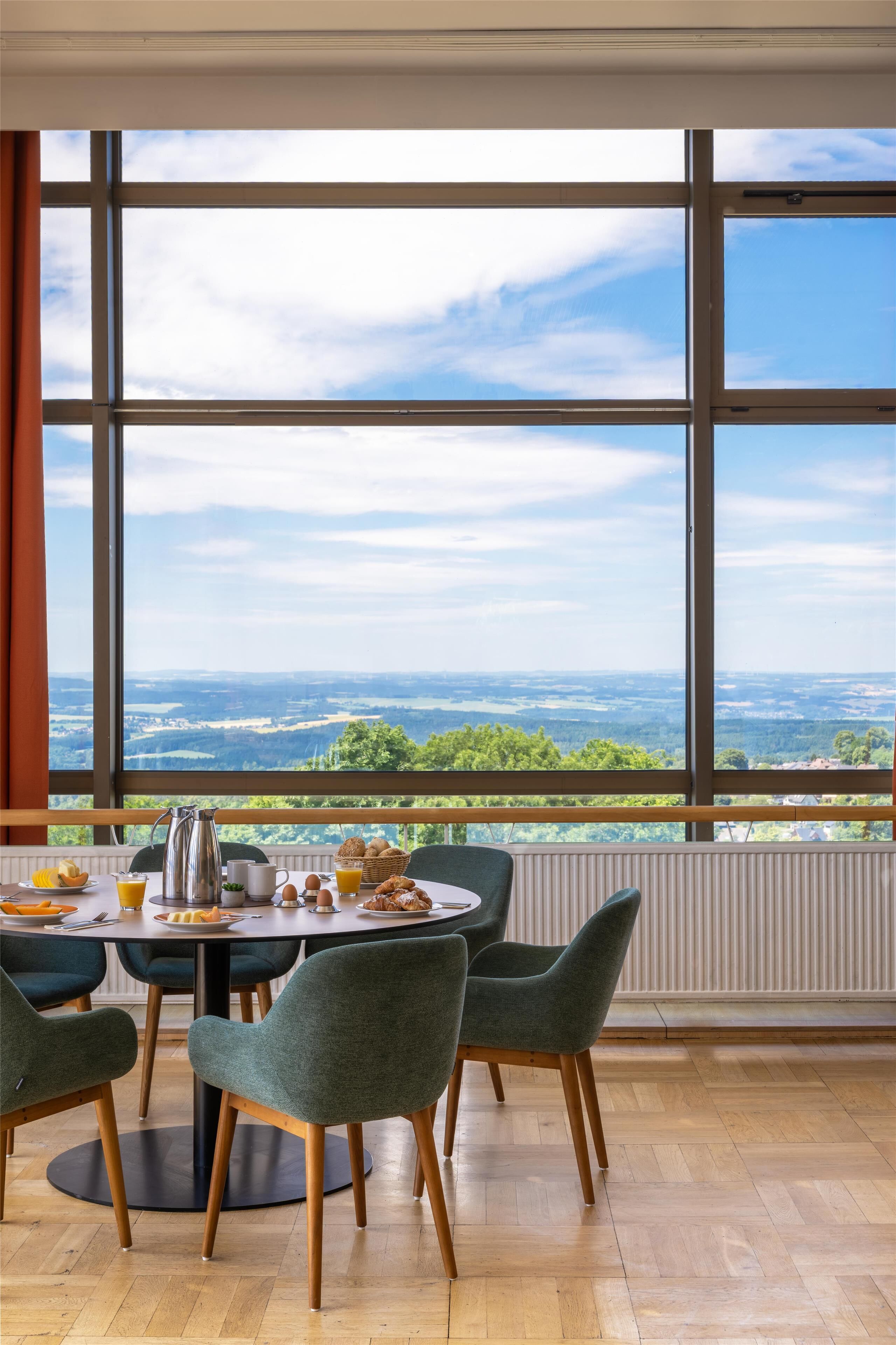 Comedor con un amplio ventanal que ofrece vistas panorámicas del campo.