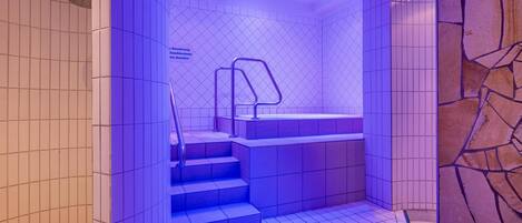 A modern bathroom with a geometric tile pattern, a built-in bench, and a shower area.