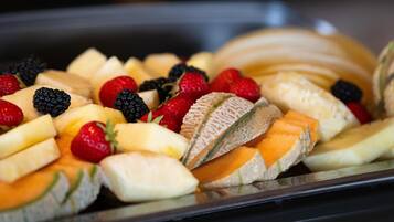 Eine Auswahl an Früchten, darunter Bananen, Erdbeeren, Brombeeren und Cantaloupe-Melone.