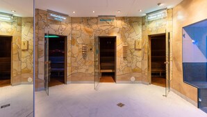 A spa area with stone walls, glass doors, and a sign indicating a sauna at 95°C. - IFA Schöneck, Hotel & Ferienpark (Schoeneck)