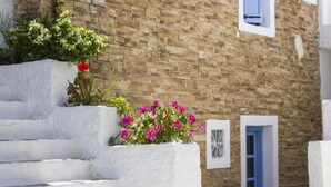 A white stone staircase leading up to a building with a brick facade. - Naxos Holidays (Naxos)