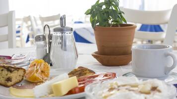 Ett frukostbord med ett urval av olika matvaror, en kaffekopp, en saltströare, en pepparströare och en krukväxt.