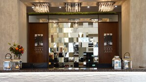 The reception area of the Killarney Oaks Hotel with a modern design, featuring a large mirror, chandeliers, and a reception desk. - Killarney Oaks Hotel (Killarney)