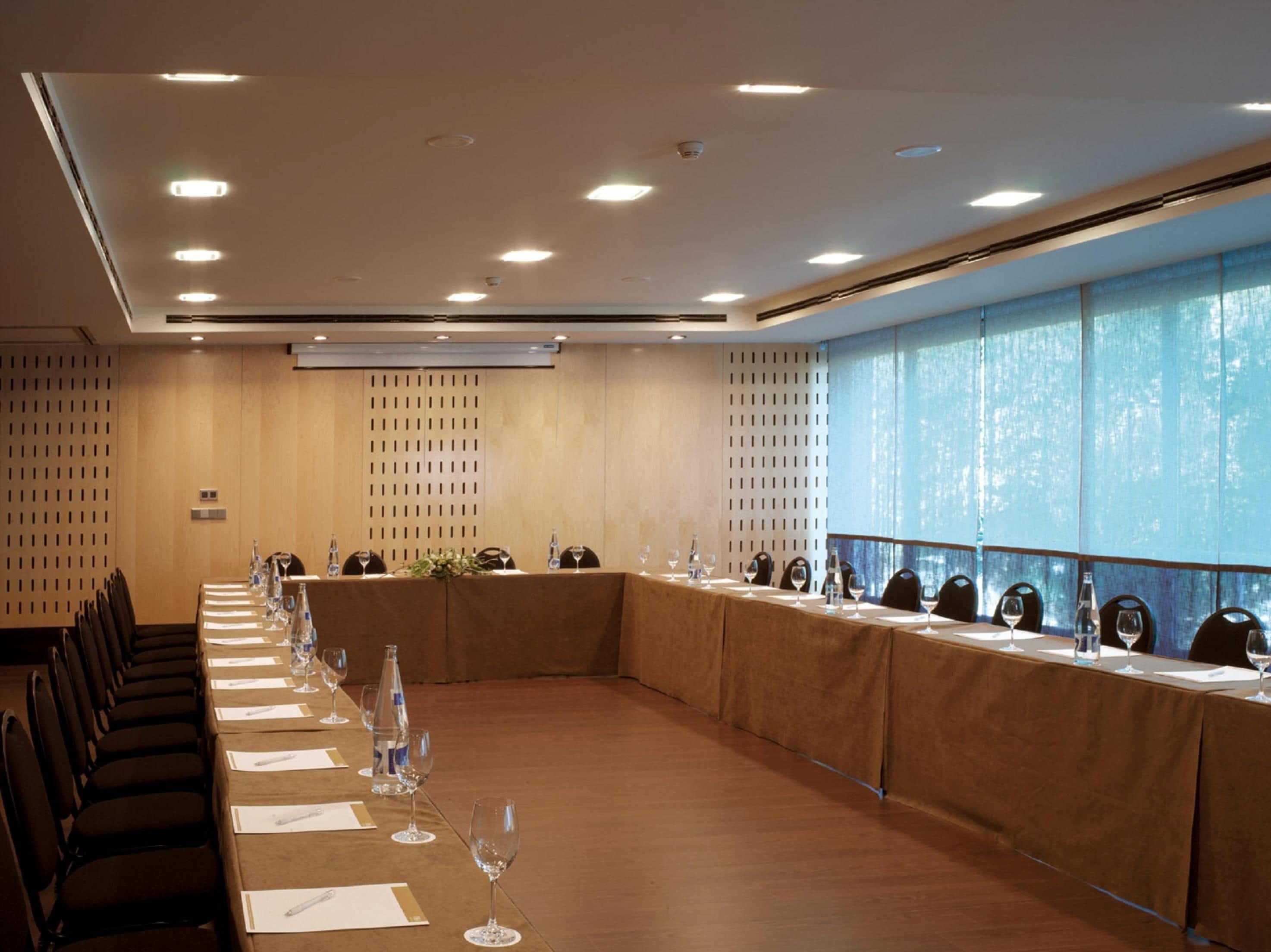 A conference room with a long table, chairs, and a large window.