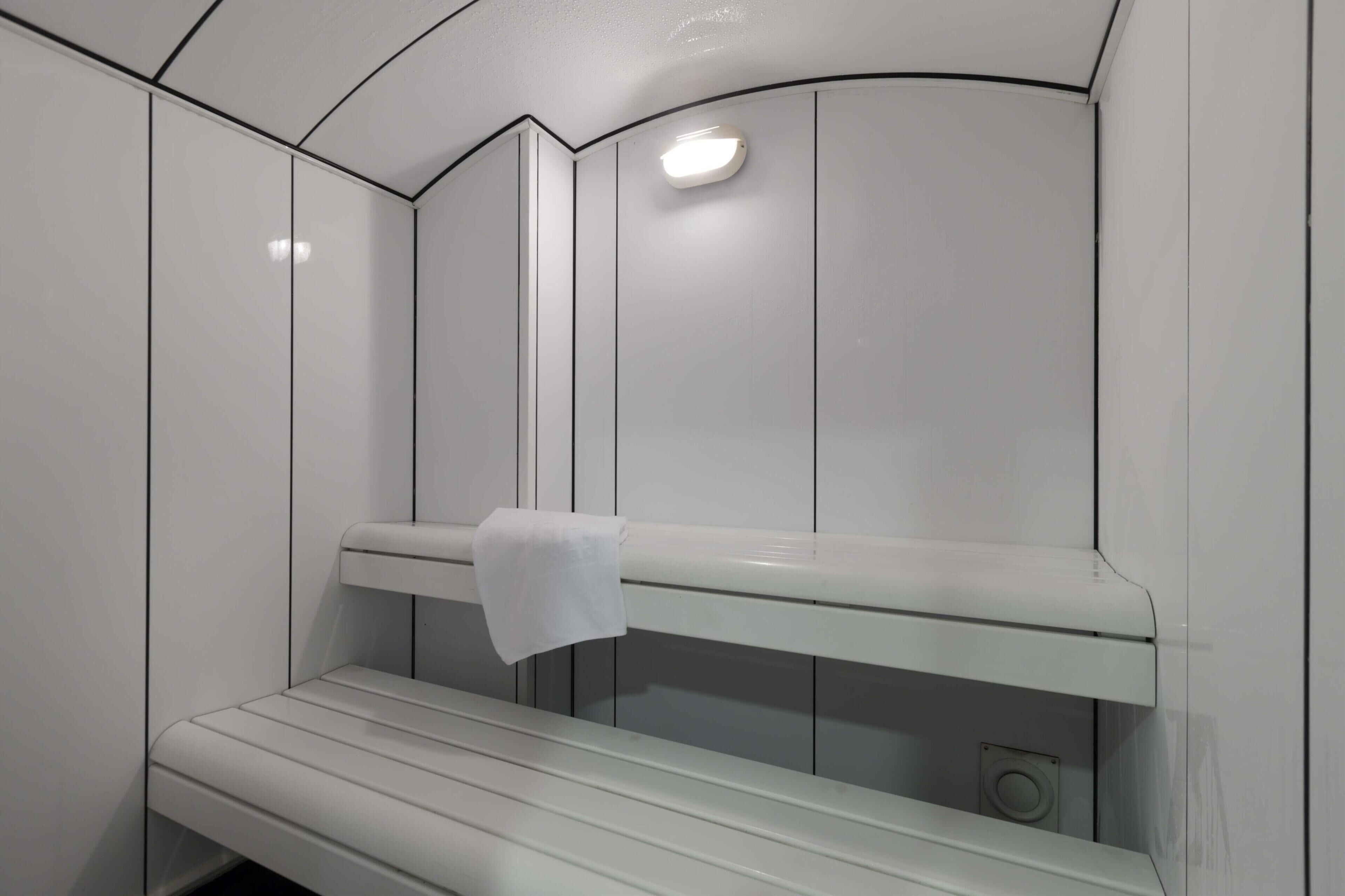 Un sauna équipé de bancs et d’un porte-serviettes.