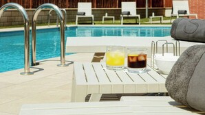 A poolside area with lounge chairs, a table with drinks, and a towel. - Sercotel Sant Boi (Sant Boi de Llobregat)