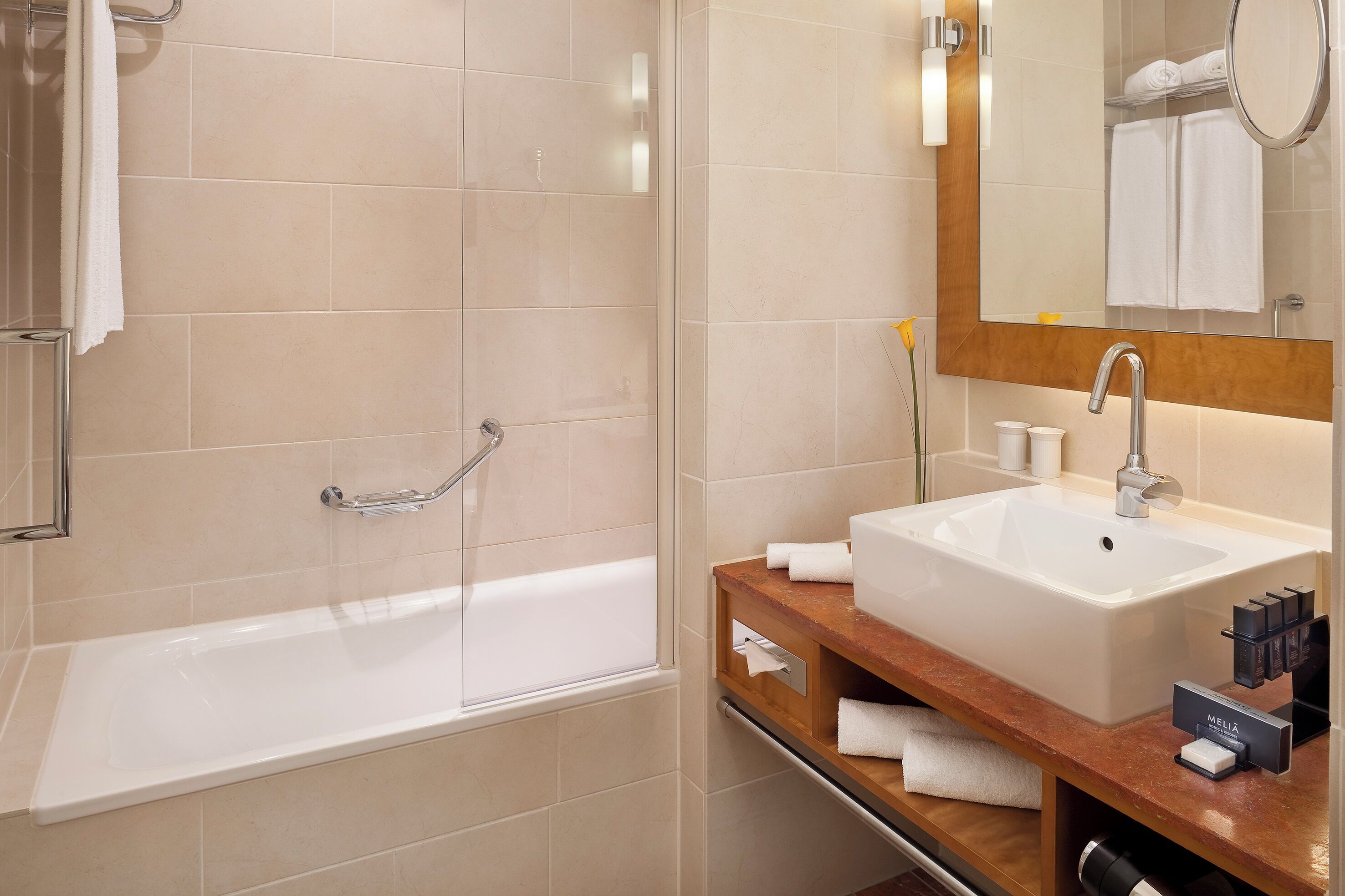A modern bathroom with a bathtub, a sink, and a vanity.