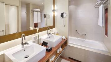 A bathroom with two sinks, a mirror, a towel rack, and a shower.