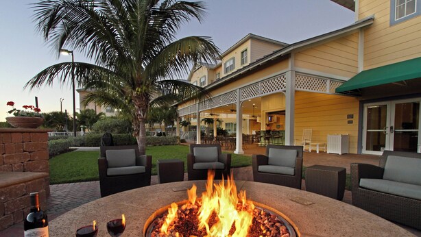 An outdoor seating area with a fire pit, patio furniture, and a building in the background.