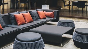 A modern indoor seating area with a sofa, ottomans, and a large potted plant. - Hotel Granados 83, a member of Preferred Hotels & Resorts (Barcelona)