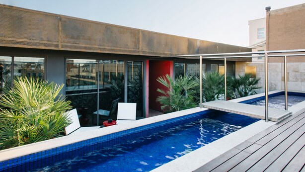 A modern outdoor pool area with a clear view of the pool, surrounded by potted plants and a wooden deck. - Hotel Granados 83, a member of Preferred Hotels & Resorts (Barcelona)