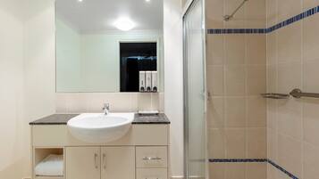 Un bagno moderno con lavandino, specchio e doccia.