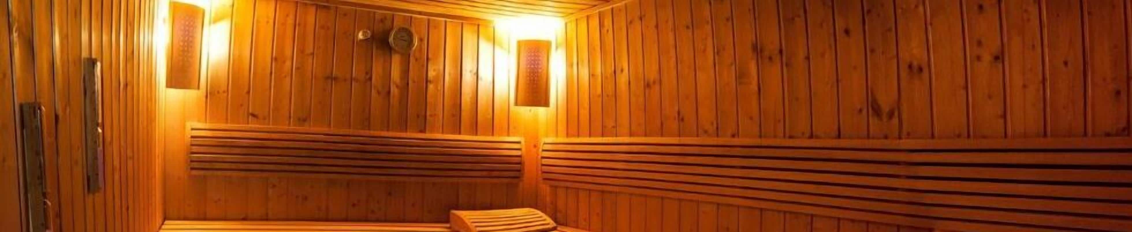 Una sauna de madera con bancos y un banco a la derecha.