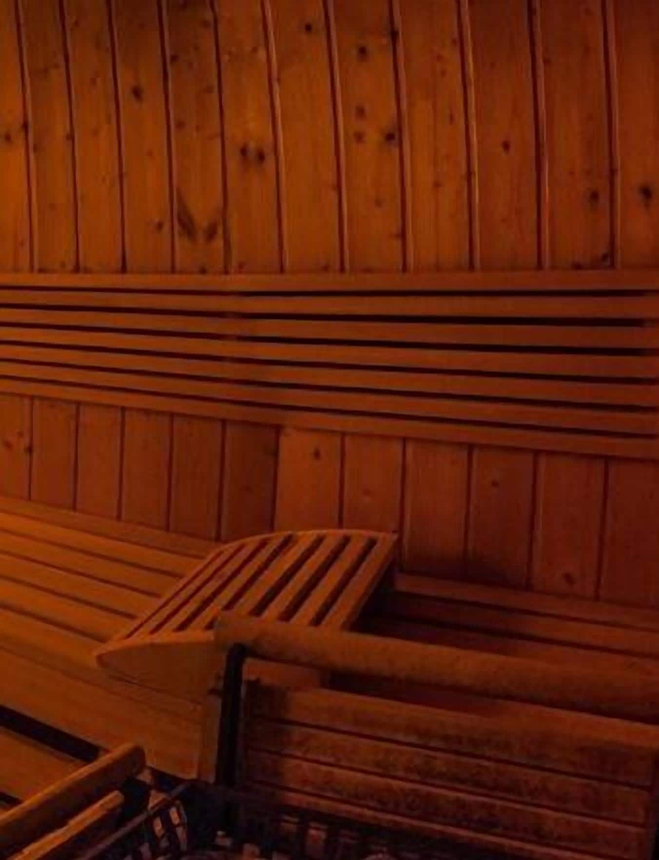 Una sauna de madera con bancos y suelo de tablones.