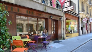 Un café con terraza, un letrero que dice "TEL DE ST. GERVAIS" y un escaparate de vidrio visible.