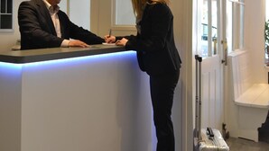 Un mostrador de recepción con un hombre y una mujer de pie.