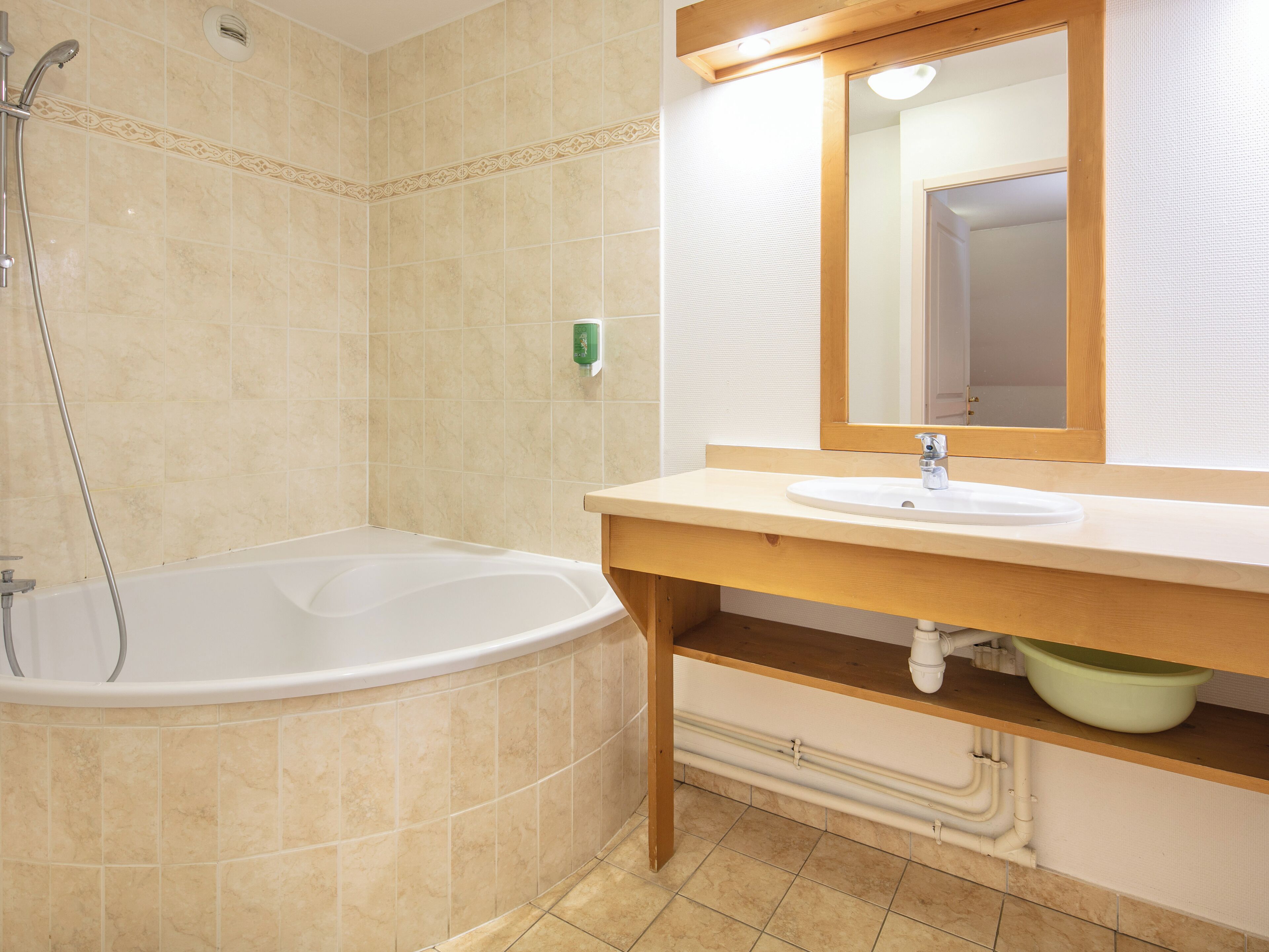 A bathroom with a bathtub, a sink, and a mirror.