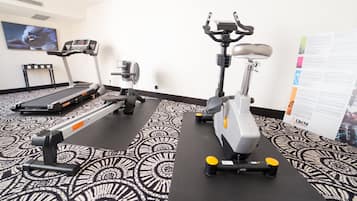 Un gimnasio con cintas de correr, elípticas y bicicletas estáticas.