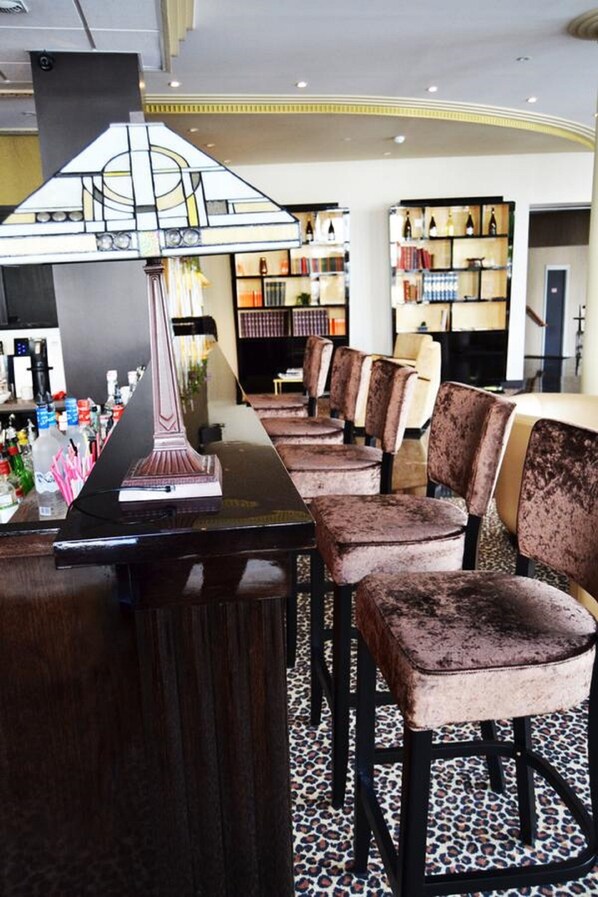 A bar area with a piano, velvet chairs, and a patterned floor. - Hotel Jehan de Beauce (Chartres)