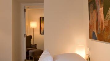 Una habitación de hotel con una cama grande, un cuadro en la pared y una lámpara.