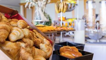 A bakery display with various baked goods, including croissants and bread, in a commercial setting.