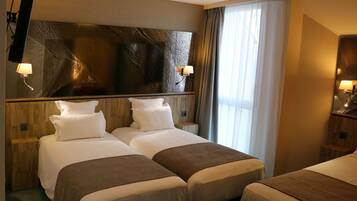 A hotel room with two beds, a large mirror, and a view of the outdoors.