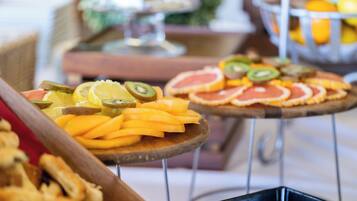 A buffet with various fruits and pastries.