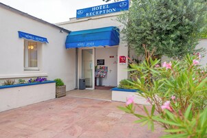 Zona de recepción de un hotel con toldo azul, un mostrador de recepción y un cartel para la recepción del hotel.